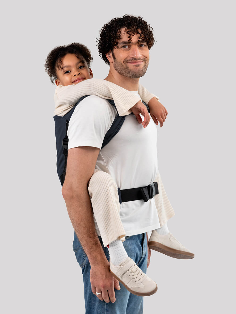 Man carrying a child in Izmi Breeze Adventure Carrier in midnight blue