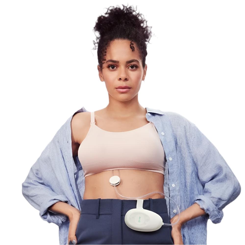 Woman wearing the Elvie Stride Breast Pump and control unit attached to her waistband.