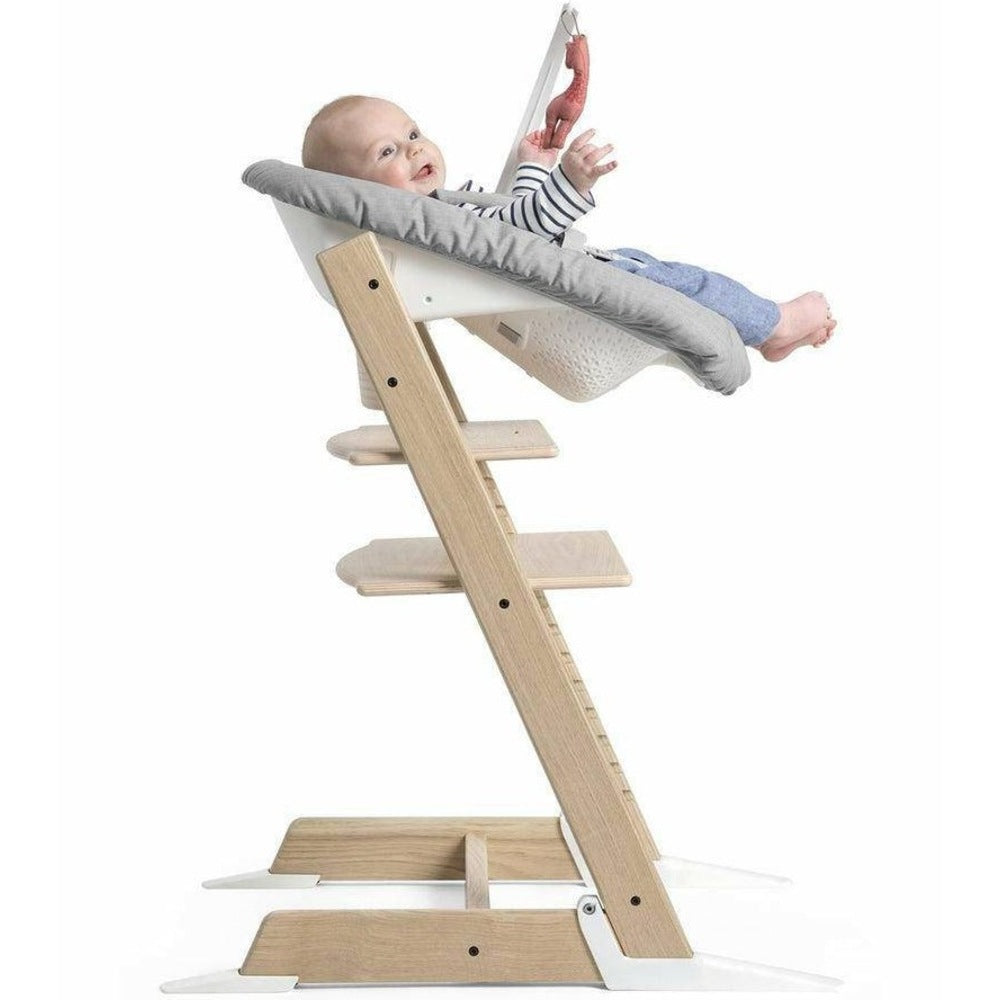 A baby seated in a Stokke Tripp Trapp high chair