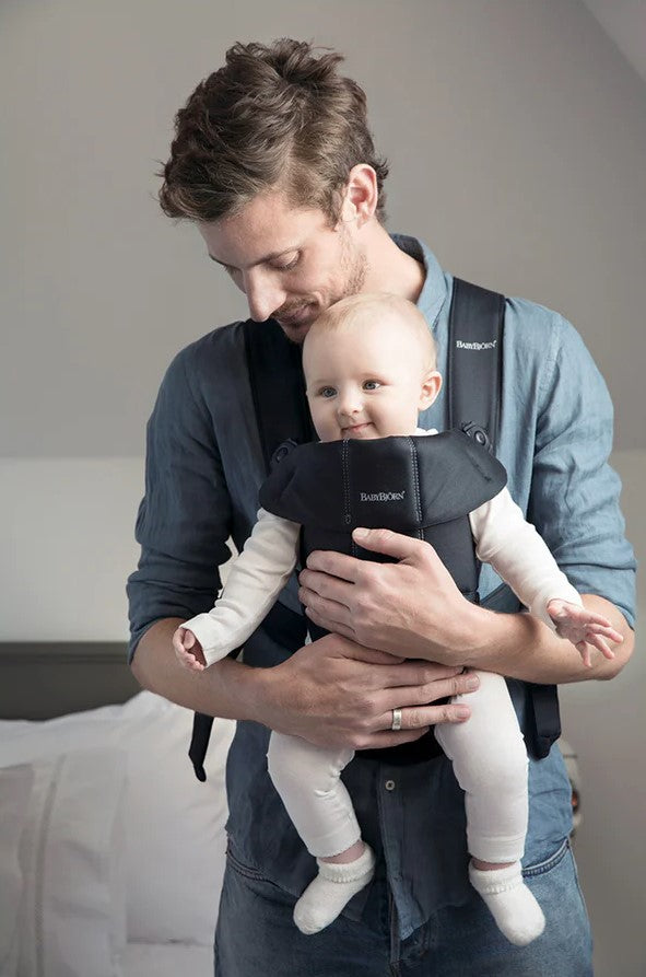 Baby Bjorn Baby Carrier Mini in black with man carrying child in the outwards facing position